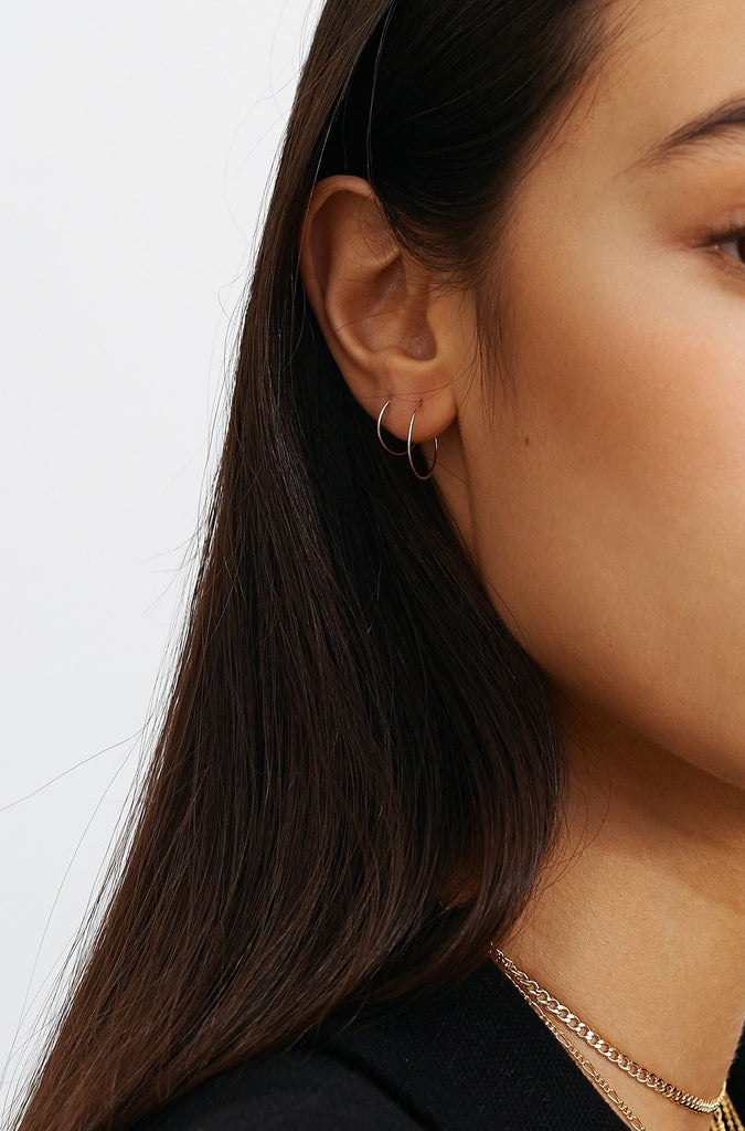 Side view of model wearing 14K 303 Mini Hoops Earrings paired with 302  Bagatiba