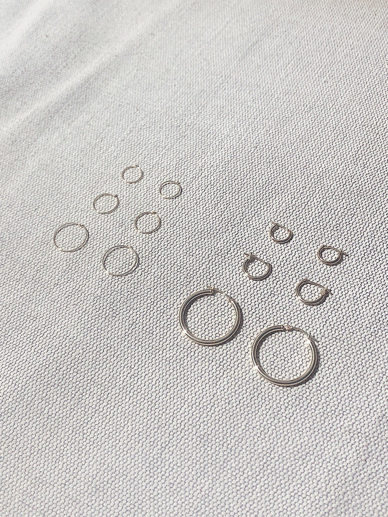 Flat lay 14K 303 Mini Hoops Earrings 1M ,2M, 3M, 14k 301, 302 hoops for size comparison Bagatiba Bagatiba