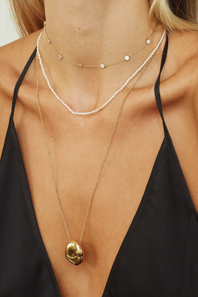 Cropped view on model of 14K Diamond Pearl Necklace layered with gold orb necklace & princess choker Necklace bagatiba