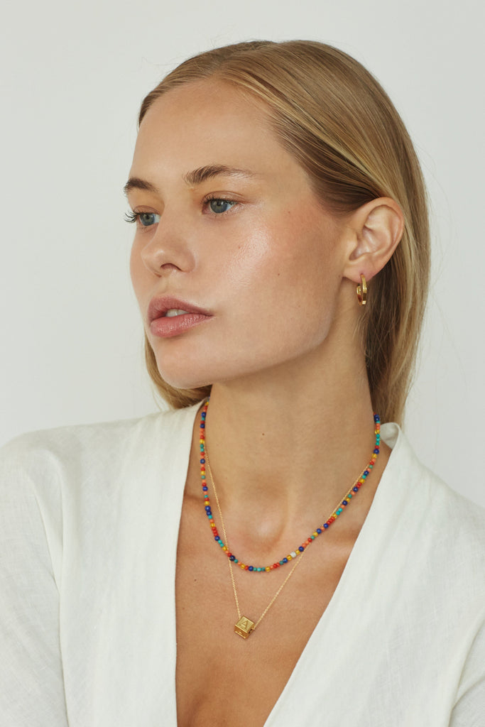 Model wearing "A" Letter Block letter on long chain paired with 14k multi bead necklace  Bagatiba