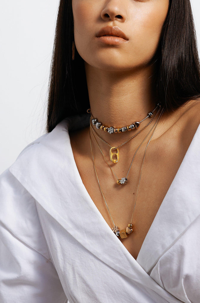 Model wearing 4 necklaces layered with "A" Letter Block letter Bagatiba