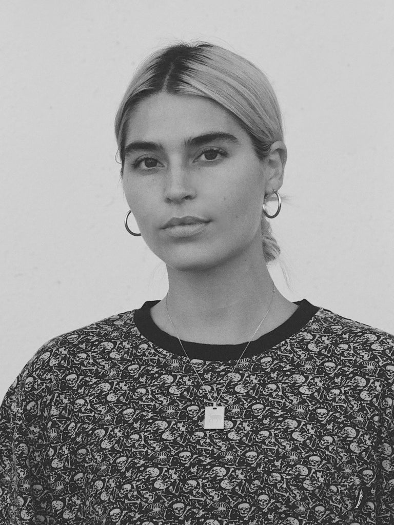Black and White photo of Model wearing an Aries Charm charm Bagatiba
