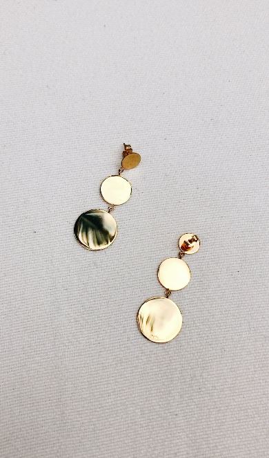 Flat lay dangle dot earrings in natural light