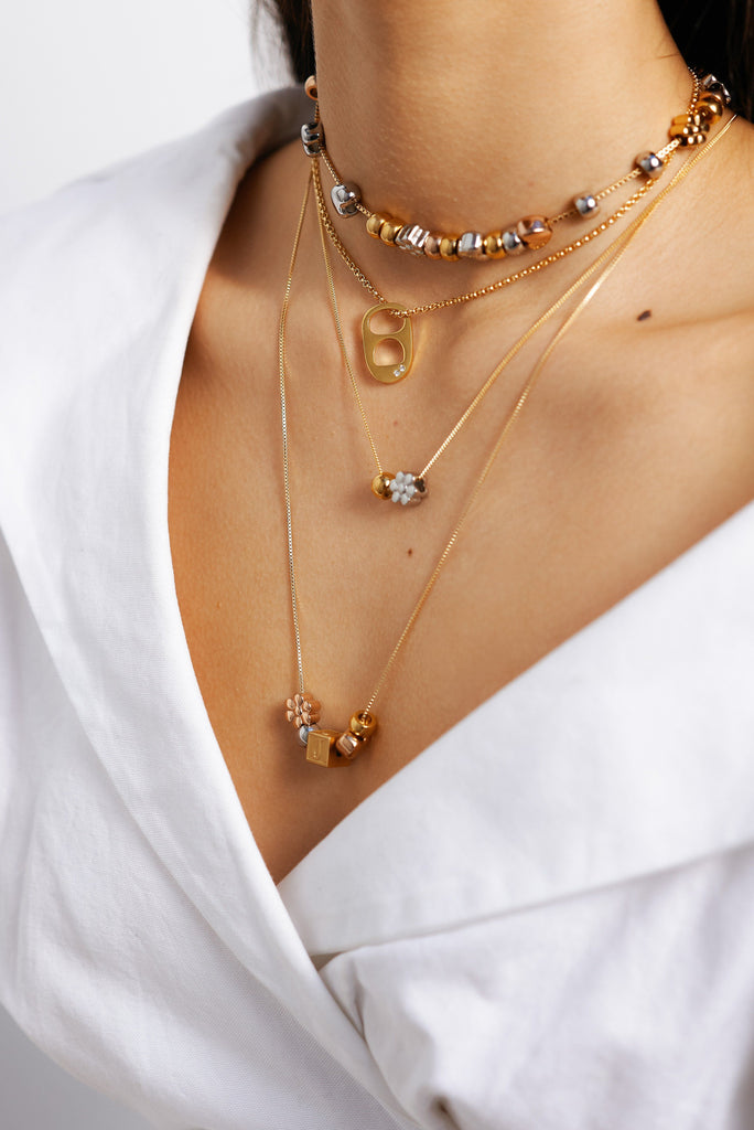 Model's neck with assortment of styles including Diamond Soda Tab Charm Necklace Bagatiba