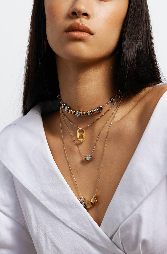 full view of model wearing 4 necklaces layered with "G" Letter Block letter on chain  Bagatiba
