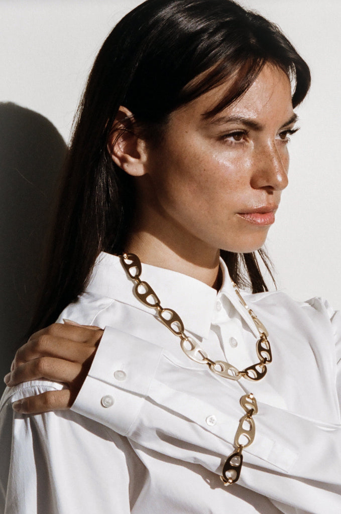 Model wearing the Gold Brushed Tab Bracelet and Necklace in natural light bagatiba