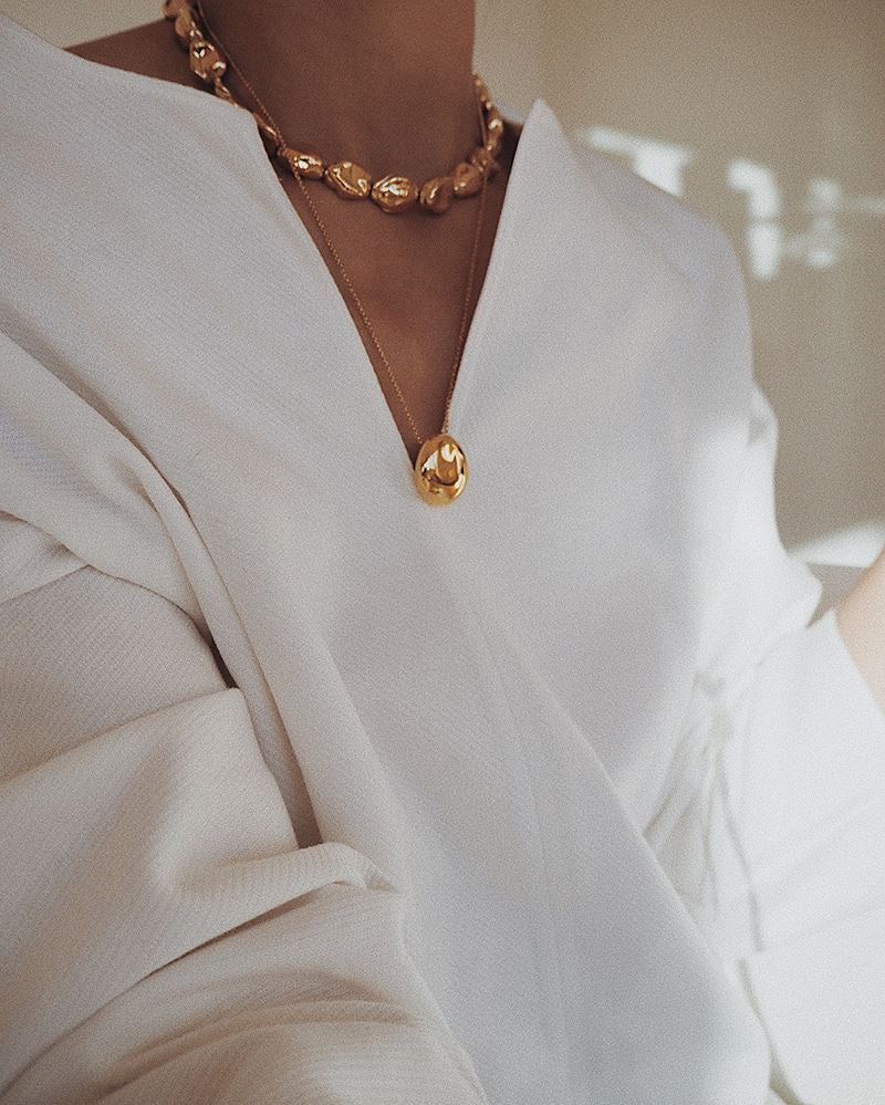 Cropped view on model in natural light wearing Gold Orb Necklace Necklace bagatiba