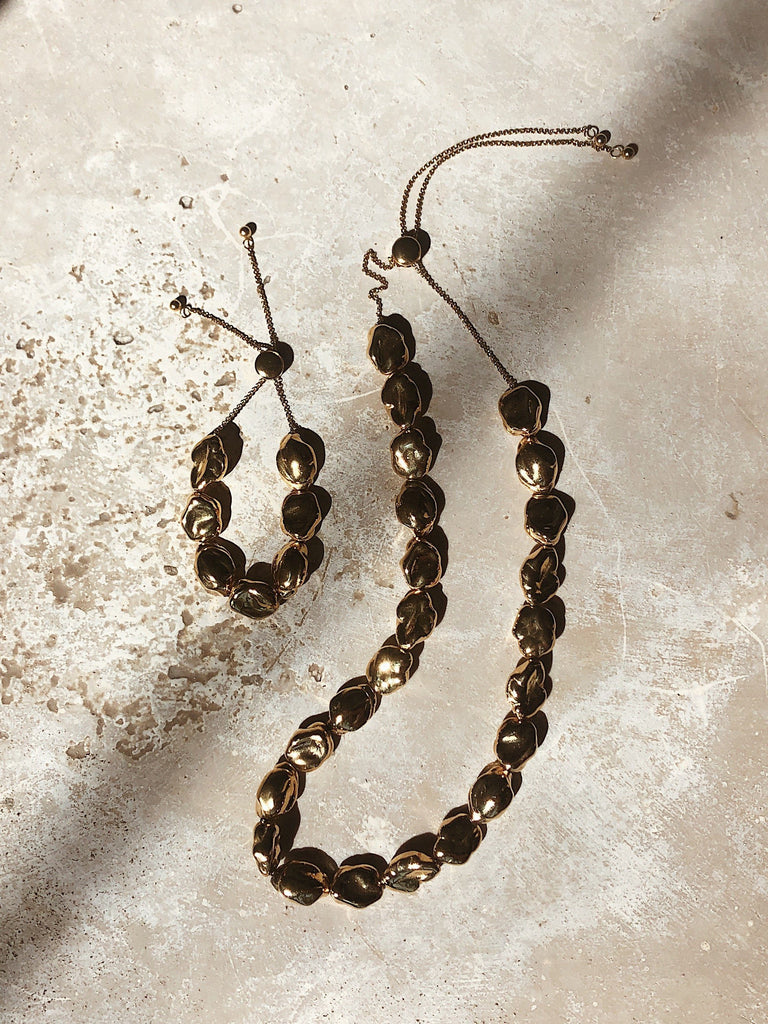 Natural light flat lay of Gold Pearl Bracelet Bracelet bagatiba