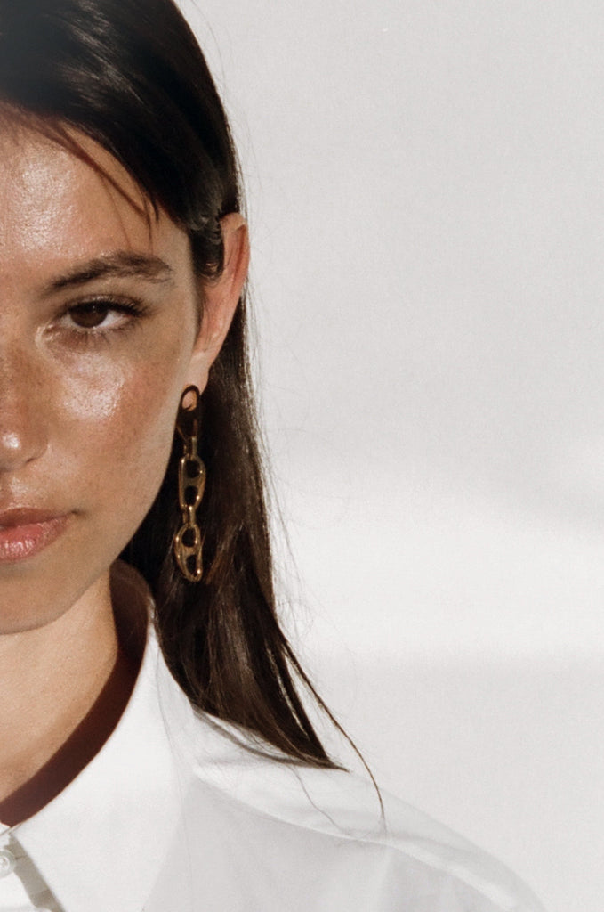Cropped view of model wearing Gold Tab Drop Earrings Earrings bagatiba