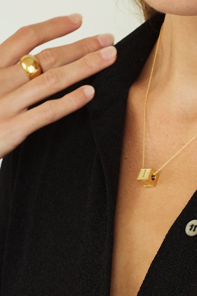 Close up on model of "I" Letter Block letter and small gold orb ring  Bagatiba