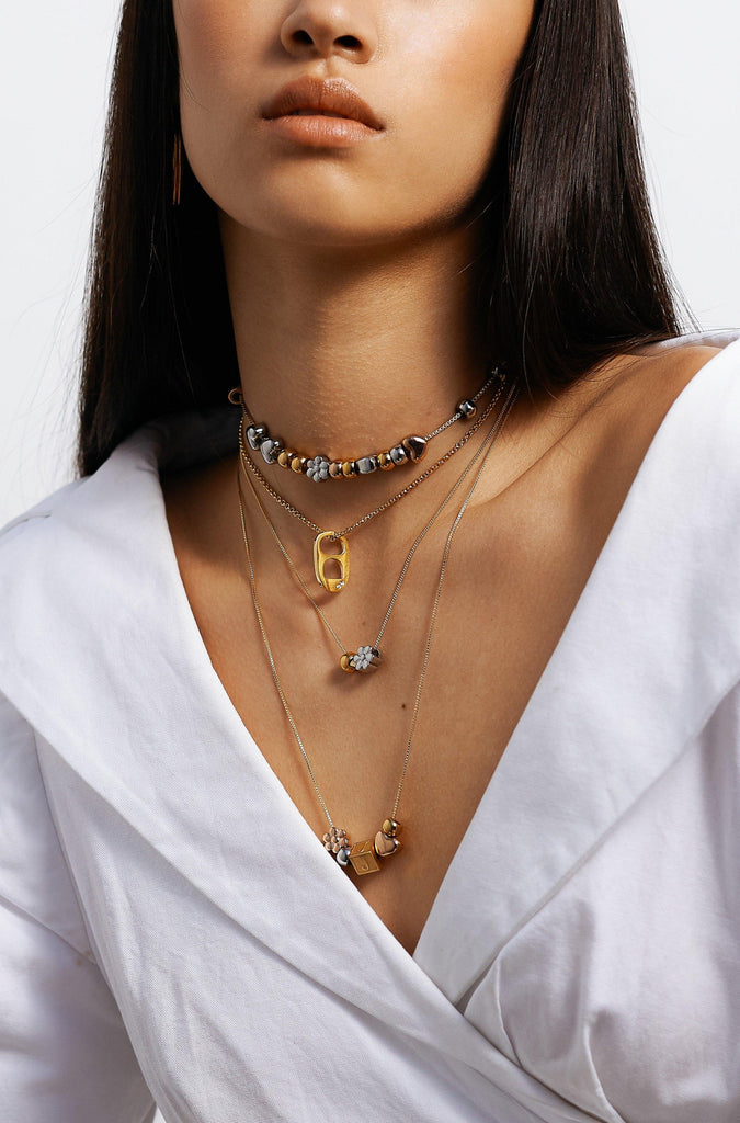 full view of model wearing 4 necklaces layered with Letter Block letters on chain Bagatiba