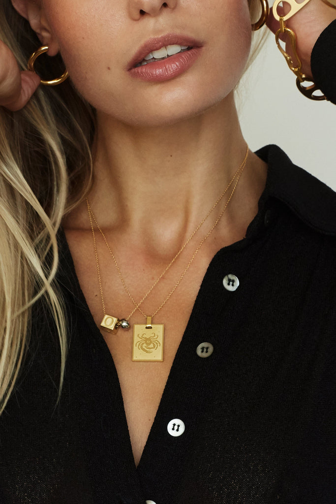 Model wearing "O" Letter Block letters layered with the zodiac charm   Bagatiba