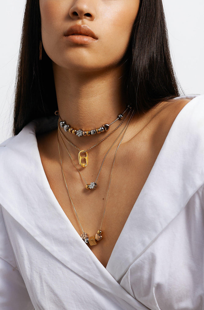 Model wearing 4 necklaces layered with  Letter Block letters Bagatiba