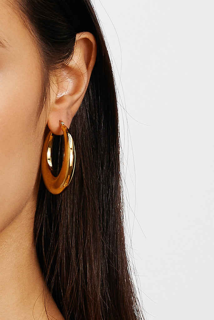 Cropped view on model's ear of Orb Hoops Earrings bagatiba