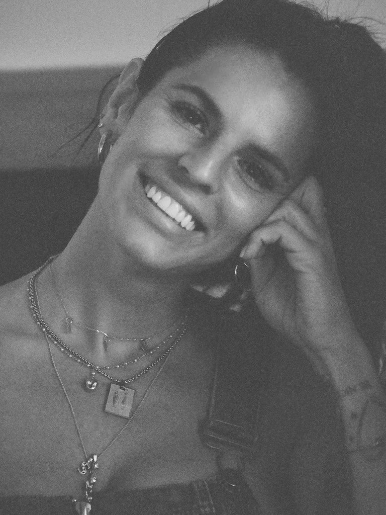 Black and White image of a woman wearing the Pisces Charm charm by Bagatiba