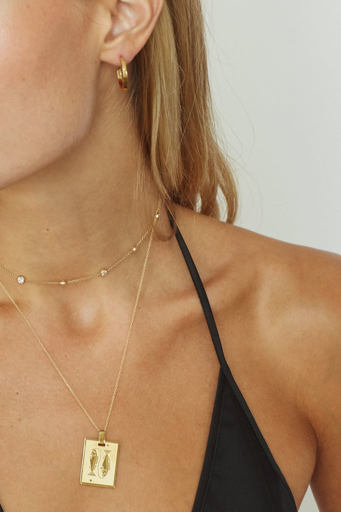 cropped view of Pisces Charm worn by model on the 18" spiral chain and paired with the princess choker  Bagatiba