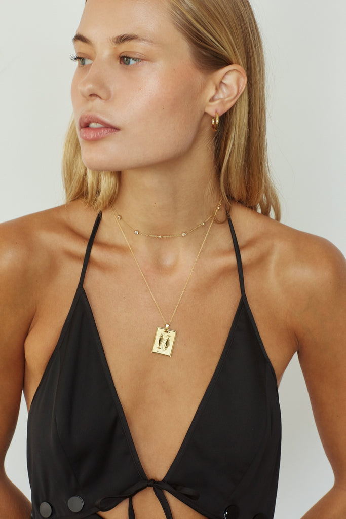 Model wearing the Pisces Charm on the 22" Vintage Square Chain by  Bagatiba