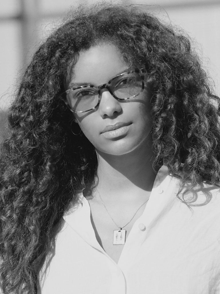 Black and White image of a woman wearing the Pisces Charm charm by Bagatiba