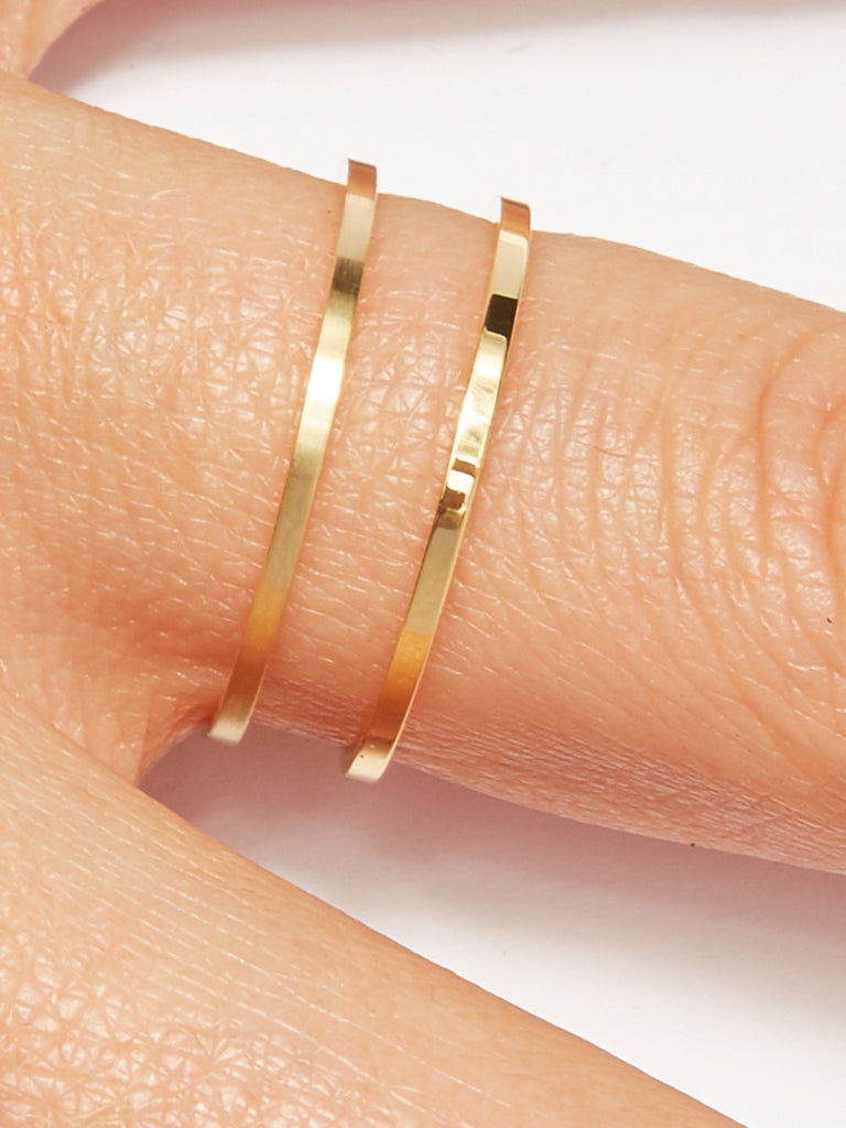 Detailed view of two Polished Gold Rings on a models finger by  Bagatiba