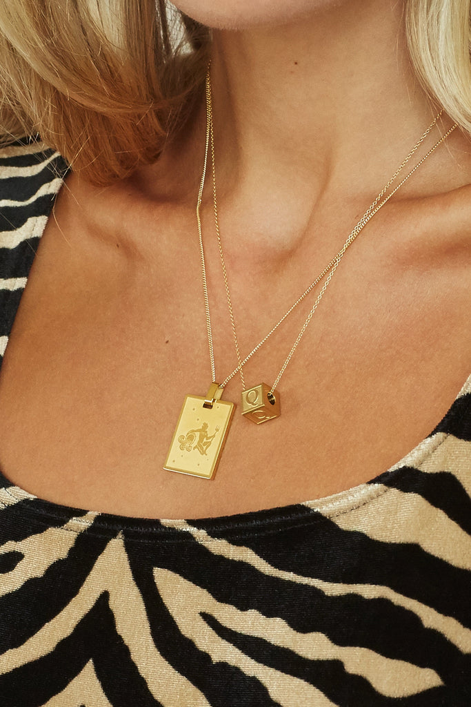 Cropped view on model "Q" Letter Block letter layered with zodiac charm on simple chains  Bagatiba