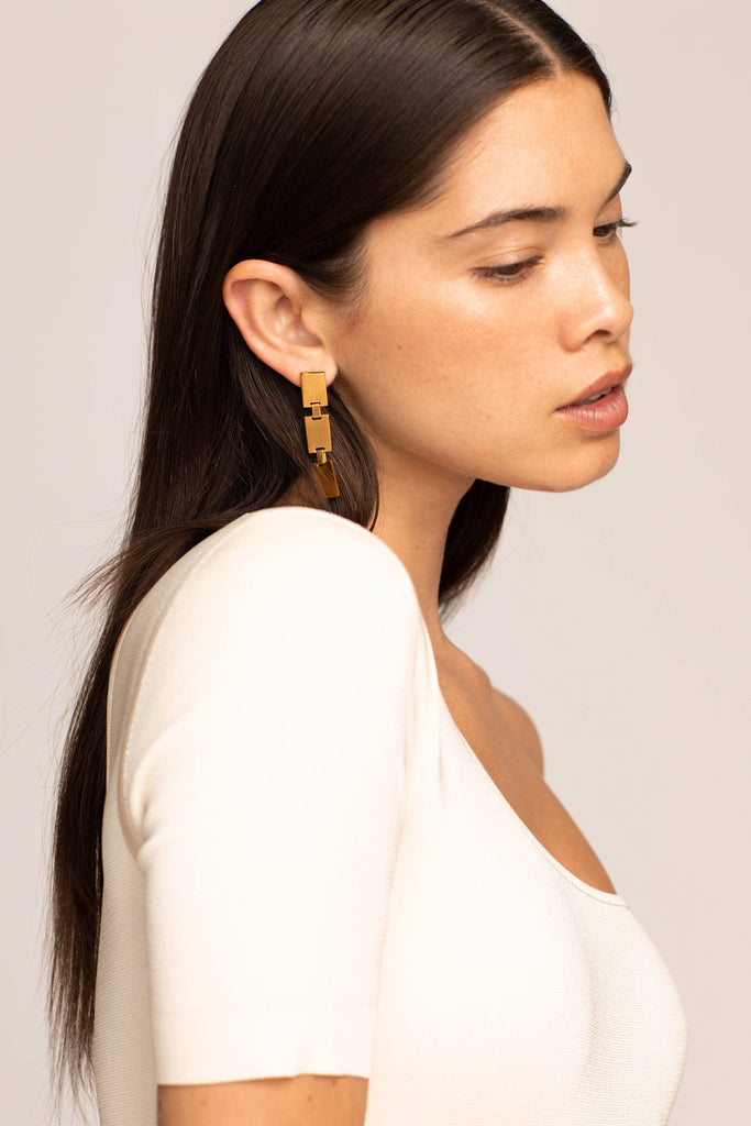 Model side profile view wearing the Rectangle Dangle Earrings by Bagatiba