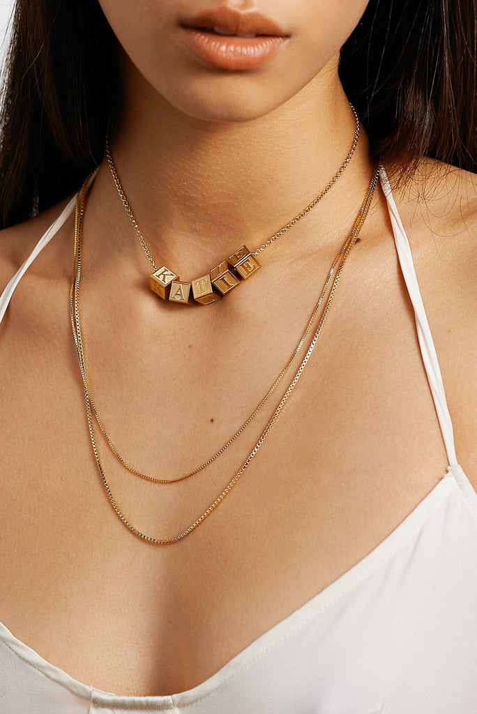 Detailed view on model of Roller Choker with added letter block charms by Bagatiba