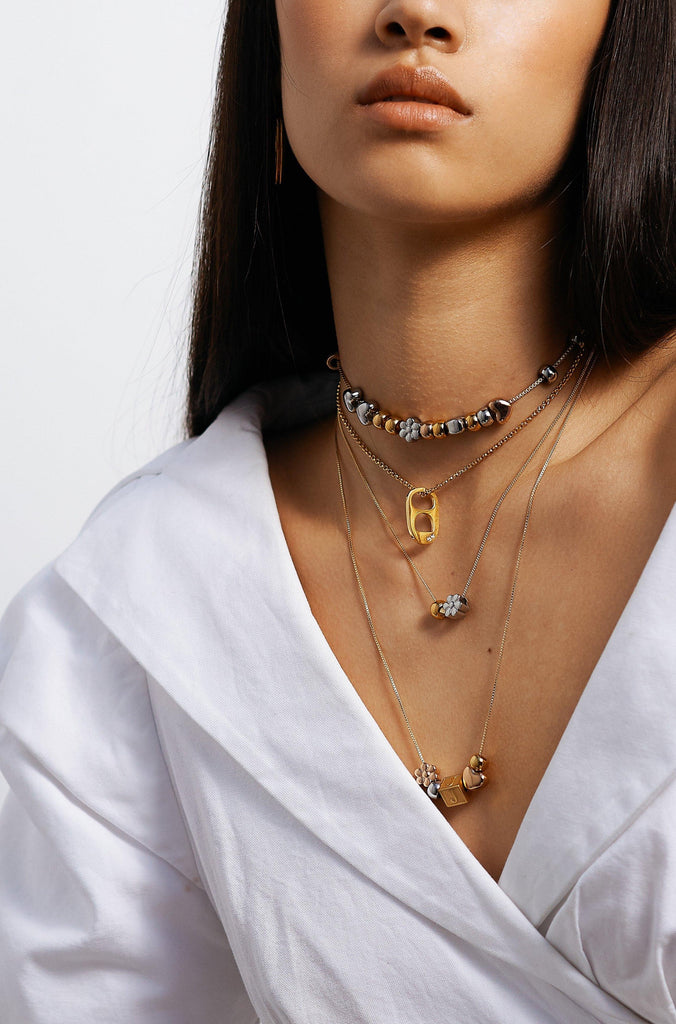 model wearing multiple necklaces with the Rose Gold Bead Set Bagatiba