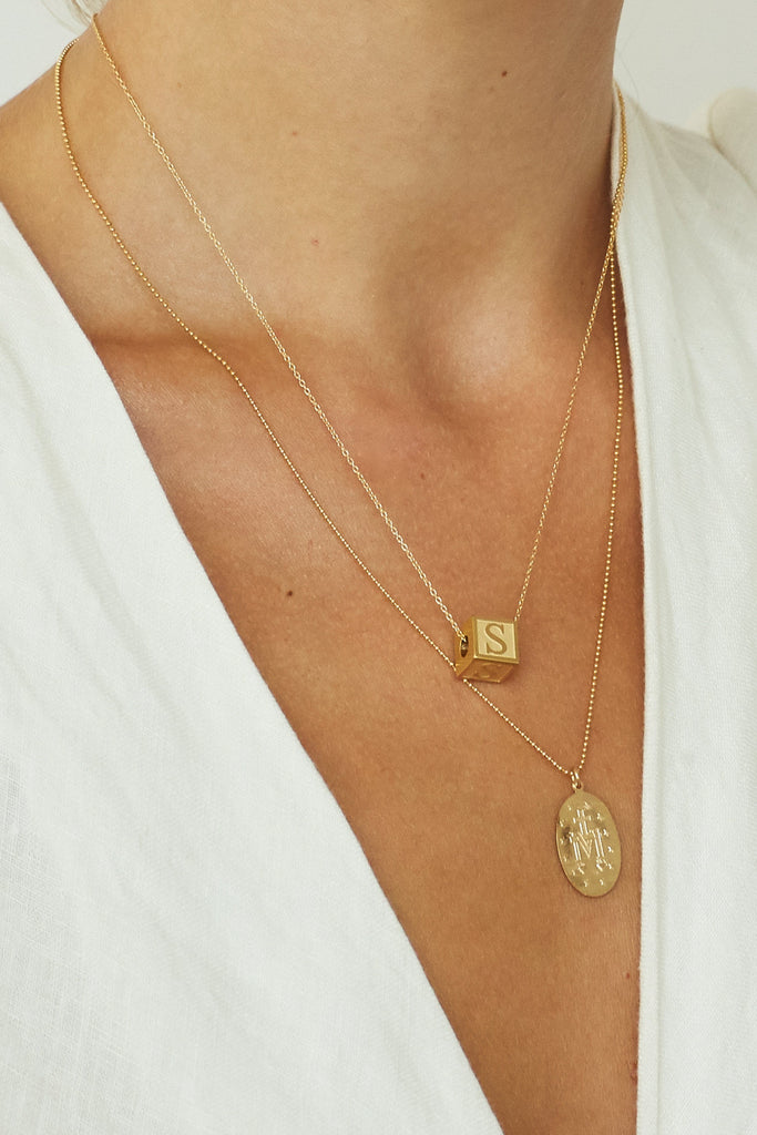 Cropped view of model wearing "S" Letter Block letter on simple chain layered with 1sm necklace  Bagatiba