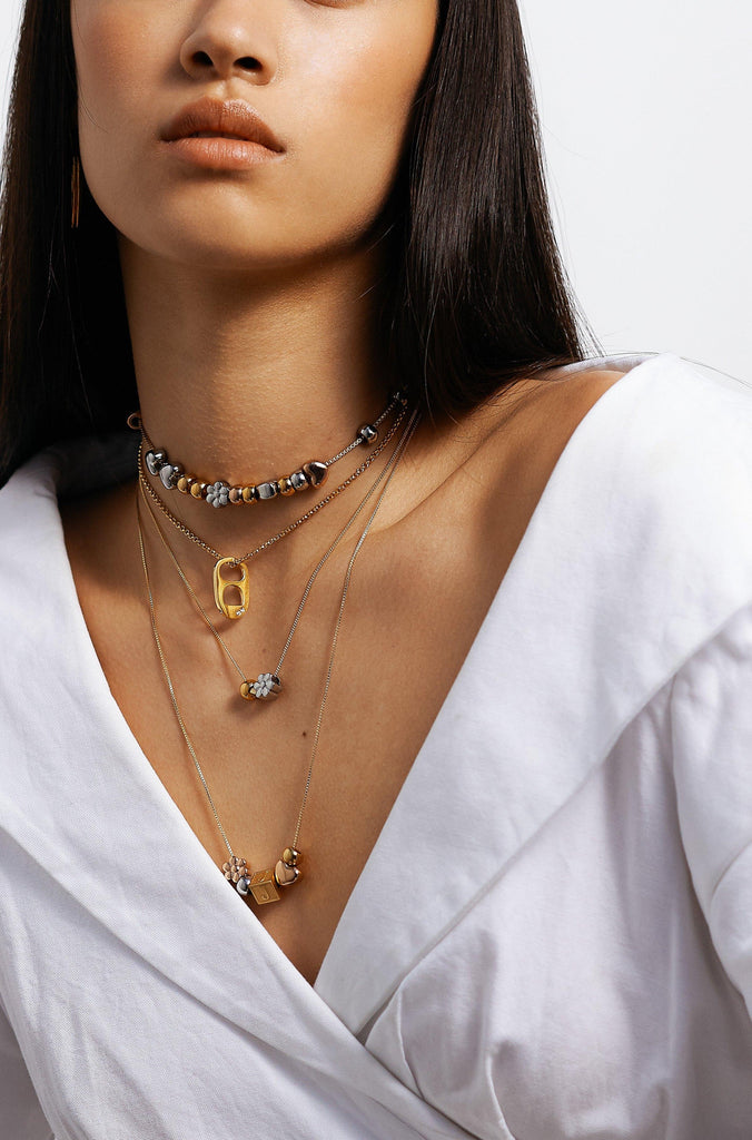Model wearing multiple sets of the Silver Bead Set styled with letter block charms by  Bagatiba