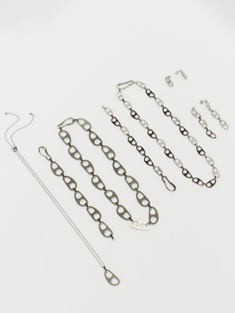 Detailed flat lay of Silver Tab Drop Earrings with the full Silver Tab Collection by  bagatiba