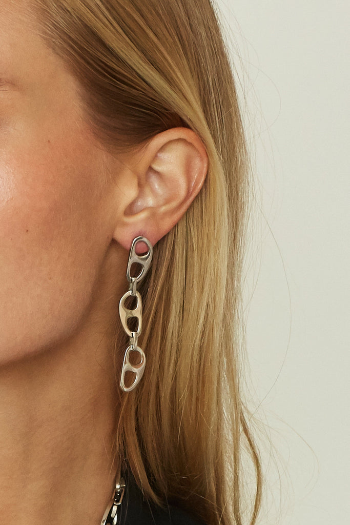 Cropped view on model's ear of Silver Tab Drop Earrings Earrings bagatiba