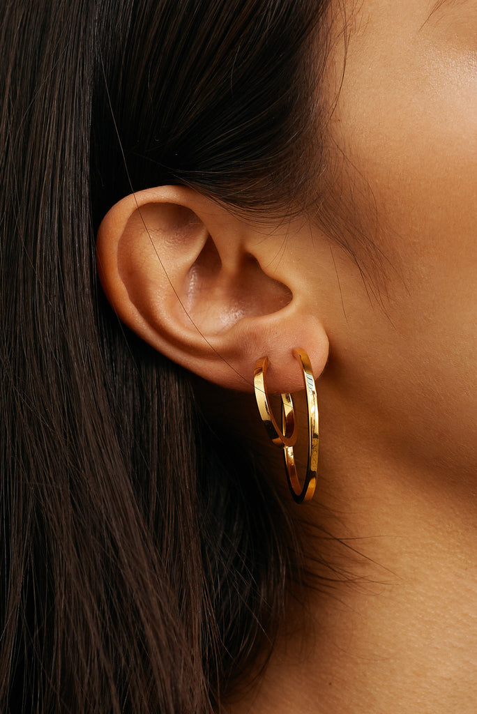 Detailed view of Simple Gold Hoops Earrings by Bagatiba on model's ear