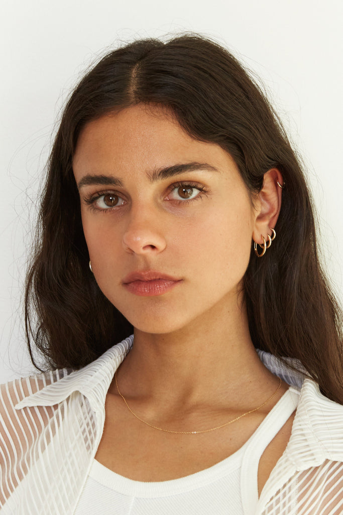 Model wearing the Small Gold Eco Huggies Earrings Bagatiba