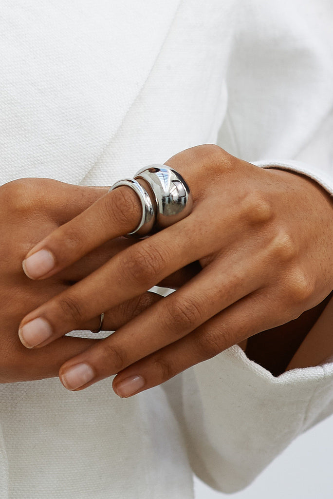 Detail view of Large and Small Silver Orb Ring by bagatiba stacked on pointer finger