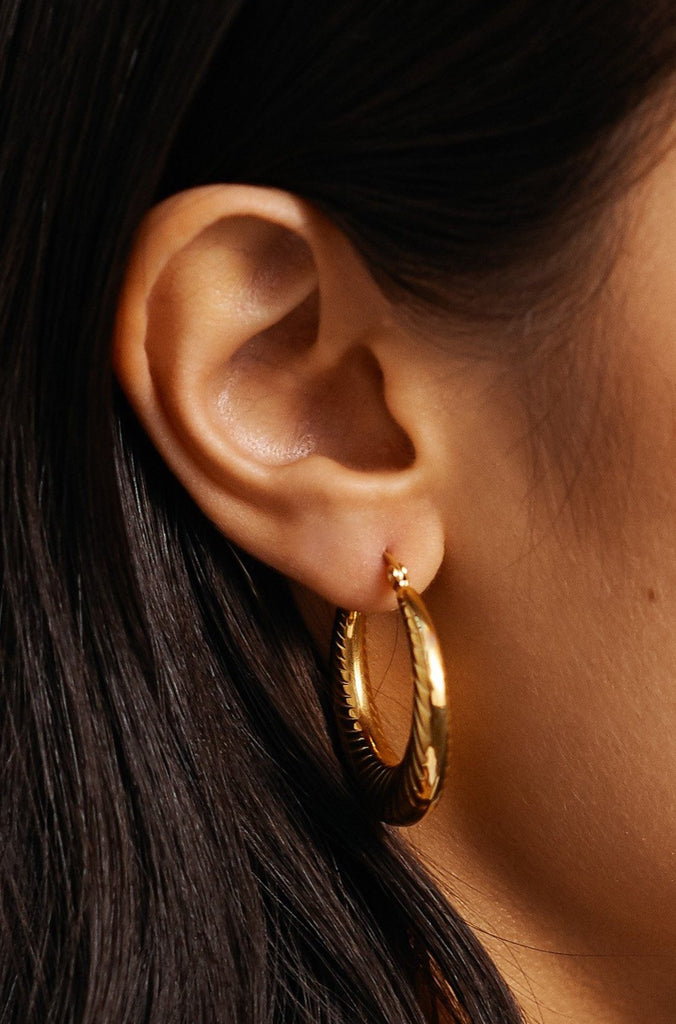 Side profile view of model in the Small Spiral Hoops Earrings bagatiba