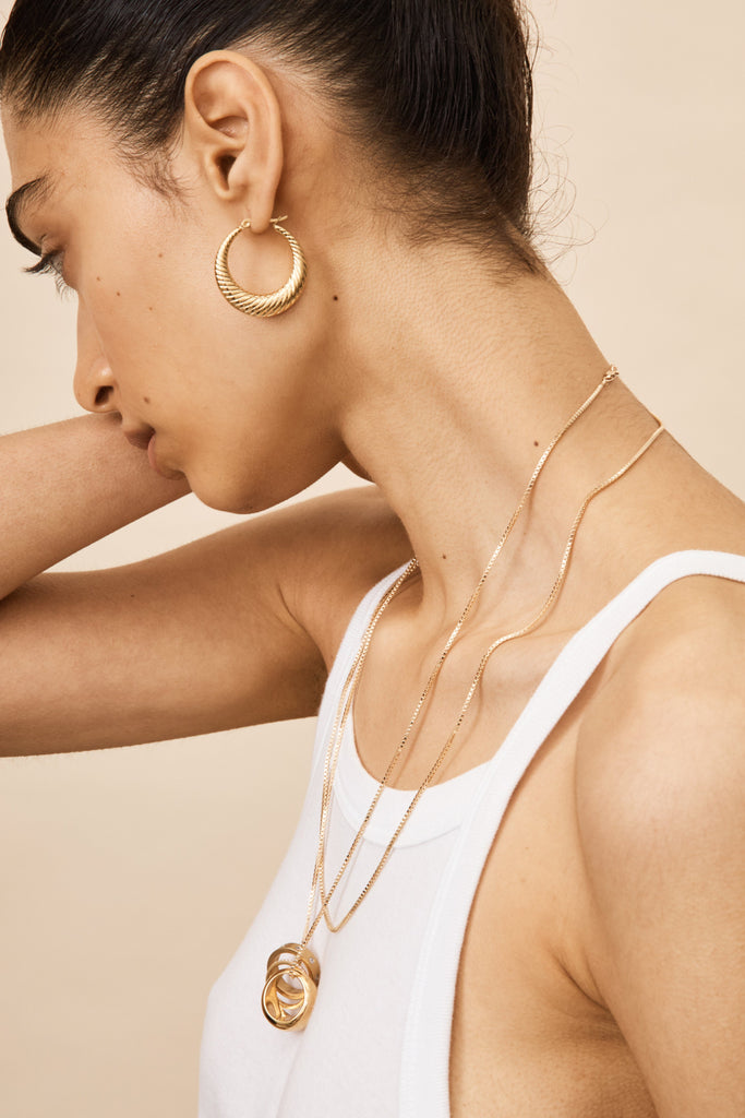 Detail view on model's ear of Small Spiral Hoops Earrings bagatiba