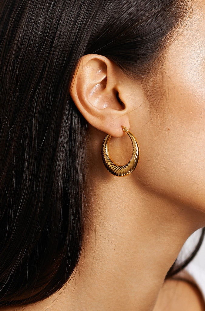 Model profile view wearing the Small Spiral Hoops Earrings bagatiba