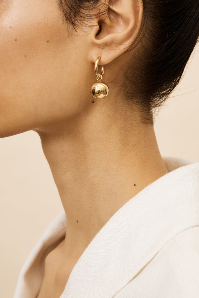 Side profile view of model's ear with the Sphere Hoops Earrings bagatiba