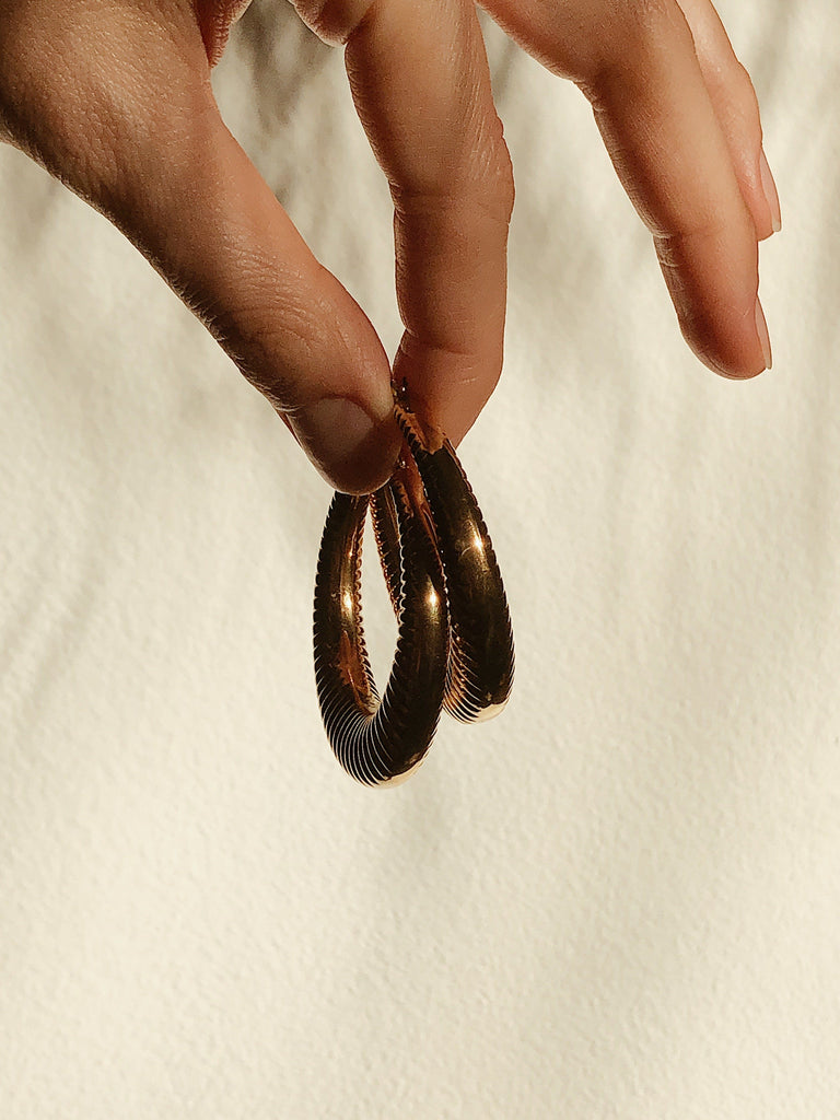 Spiral Hoops Earrings by bagatiba held in natural light