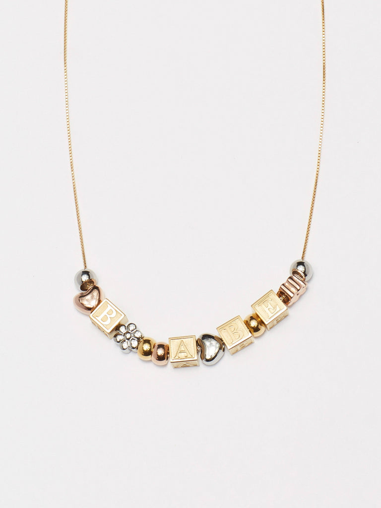 close up flat lay of "B" "A" "B" "E" Letter Block letters on chain with mixed beads Bagatiba