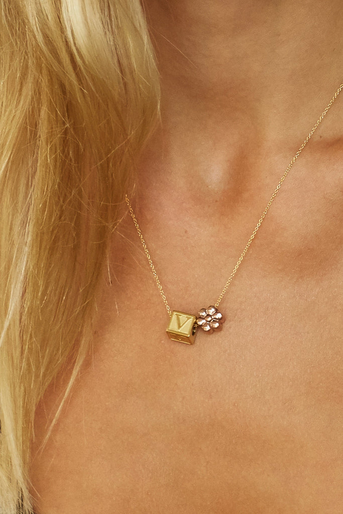Cropped view of model wearing "V" Letter Block letter and flower bead on chain  Bagatiba