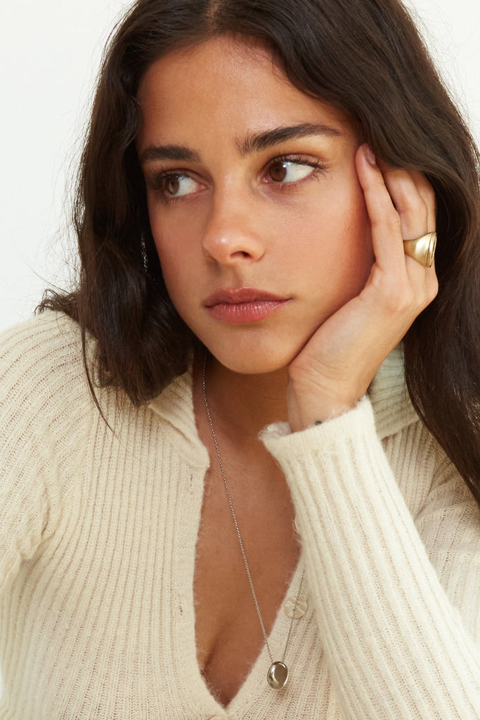 Side view on model's hand of the Yin Yang Glass Ring Necklace bagatiba