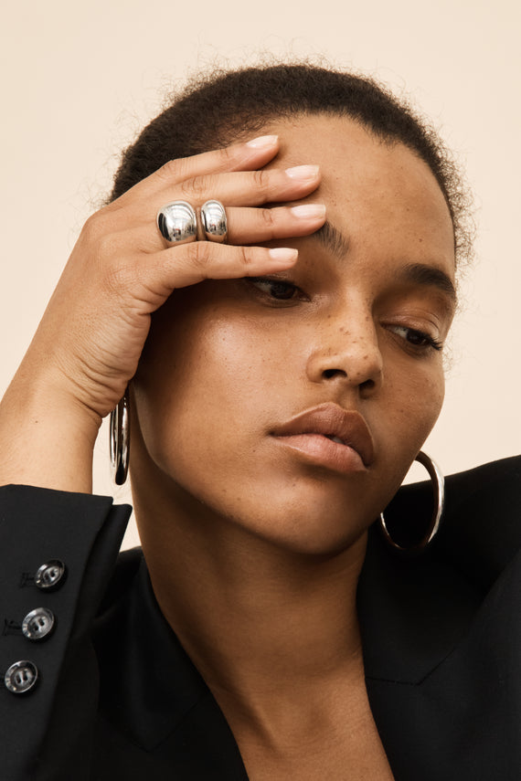 model wearing silver rings and hoops
