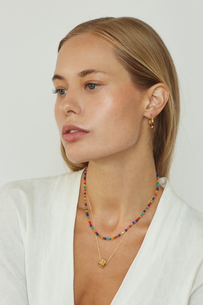 Model wearing "A" Letter Block letter on long chain paired with 14k multi bead necklace  Bagatiba 