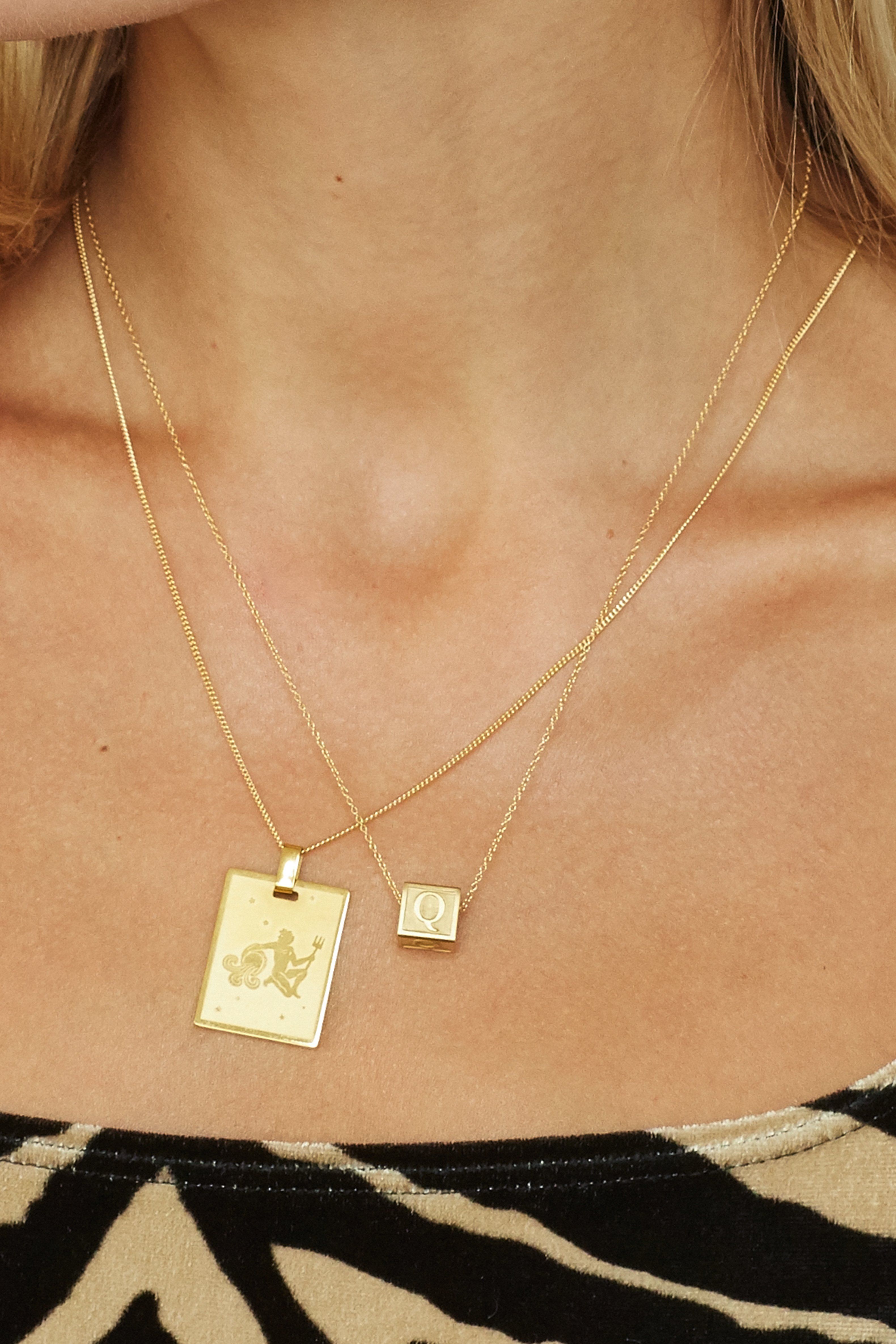 Cropped view of model wearing Aquarius Charm layered with letter block charm  Bagatiba 