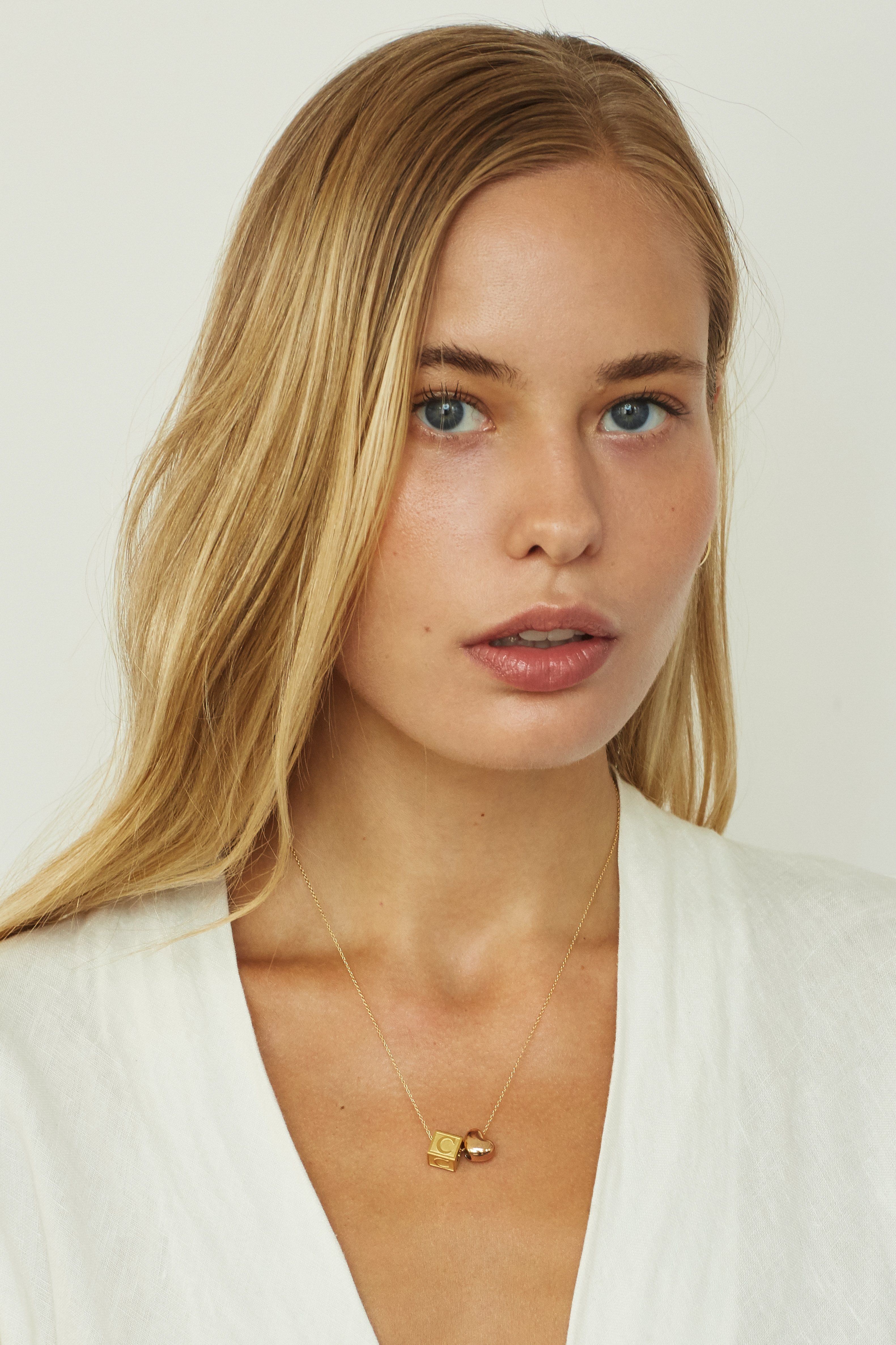 Model wearing "C" Letter Block letter on long chain with rose heart beadBagatiba