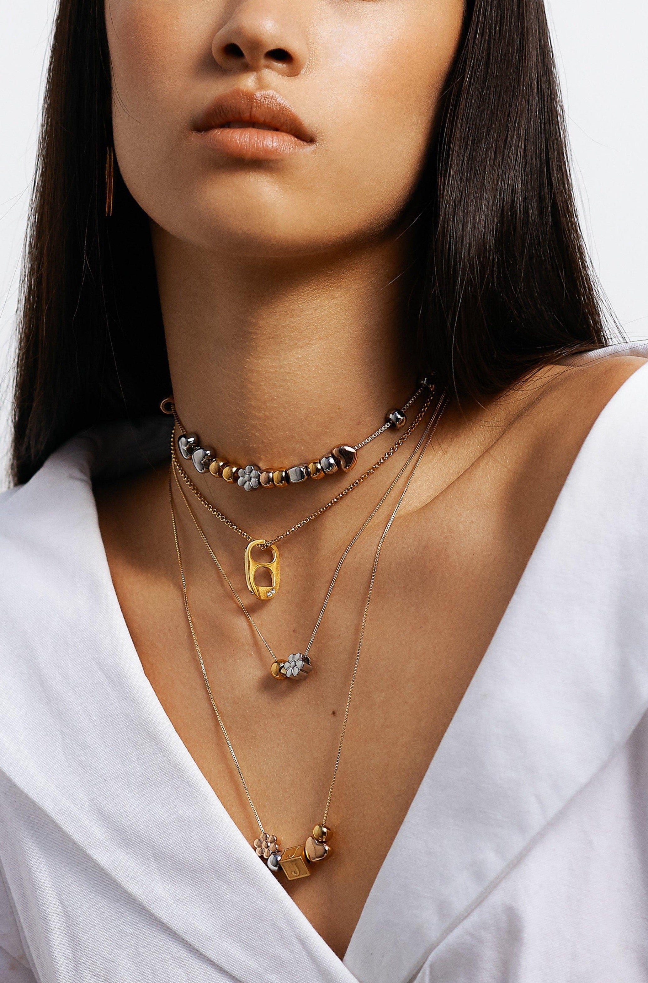 Model wearing 4 necklaces layered with "A" Letter Block letter Bagatiba