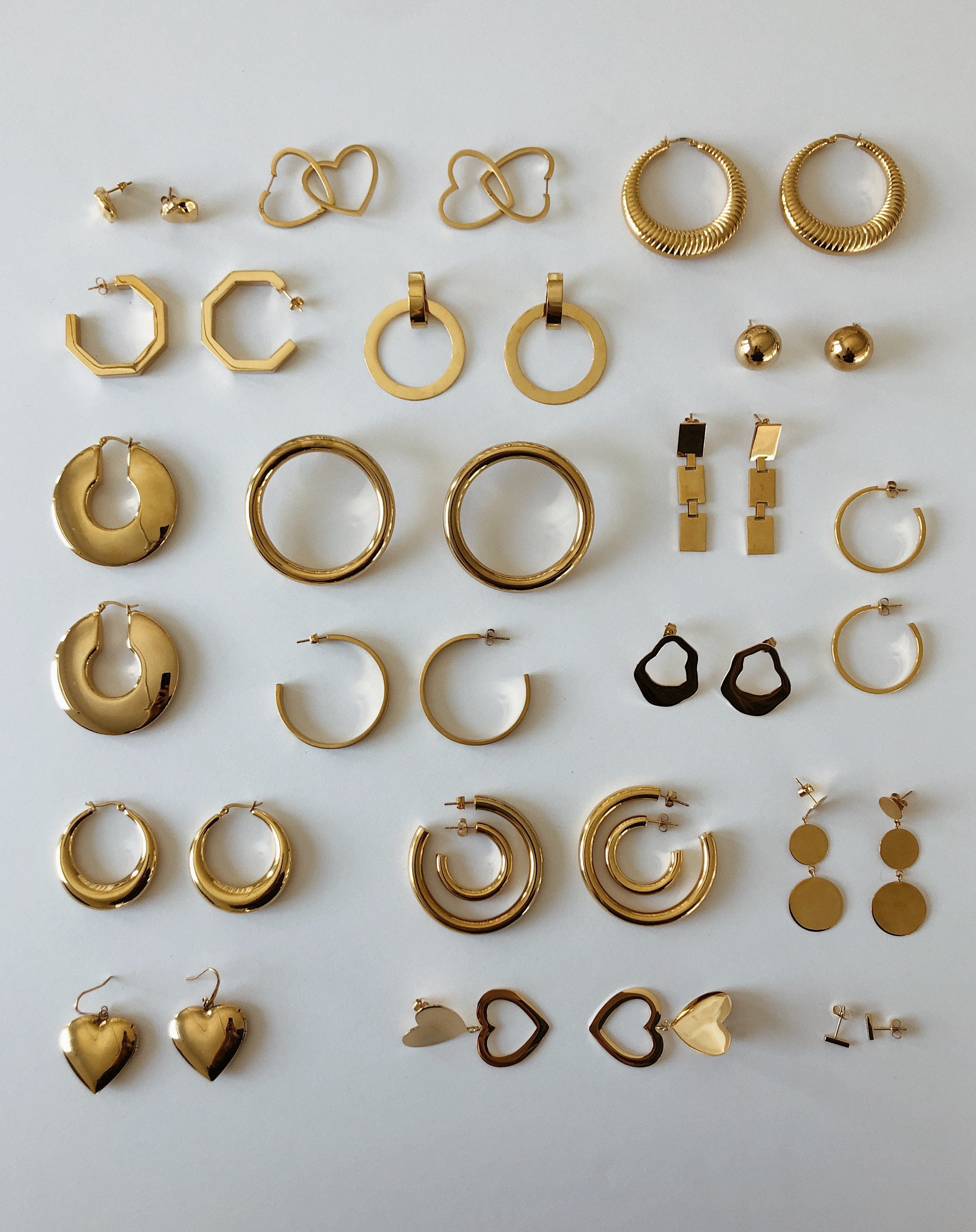 Full view flat lay of assorted earrings including the Double Heart Hoops Earrings bagatiba 