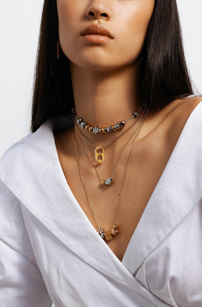 Model wearing 4 necklaces layered with Letter Block letters Bagatiba