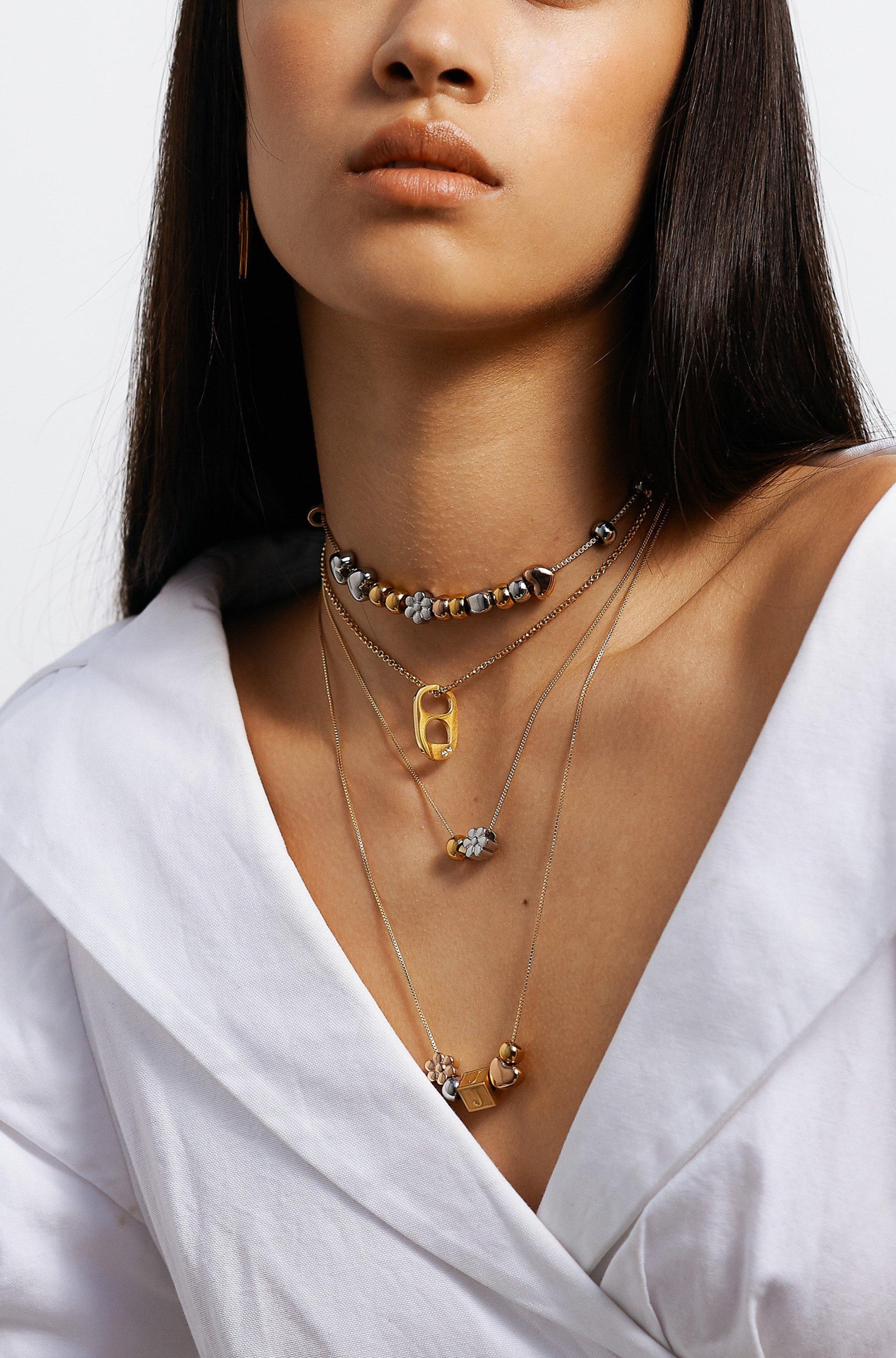 full view of model wearing 4 necklaces layered with "G" Letter Block letter on chain  Bagatiba 